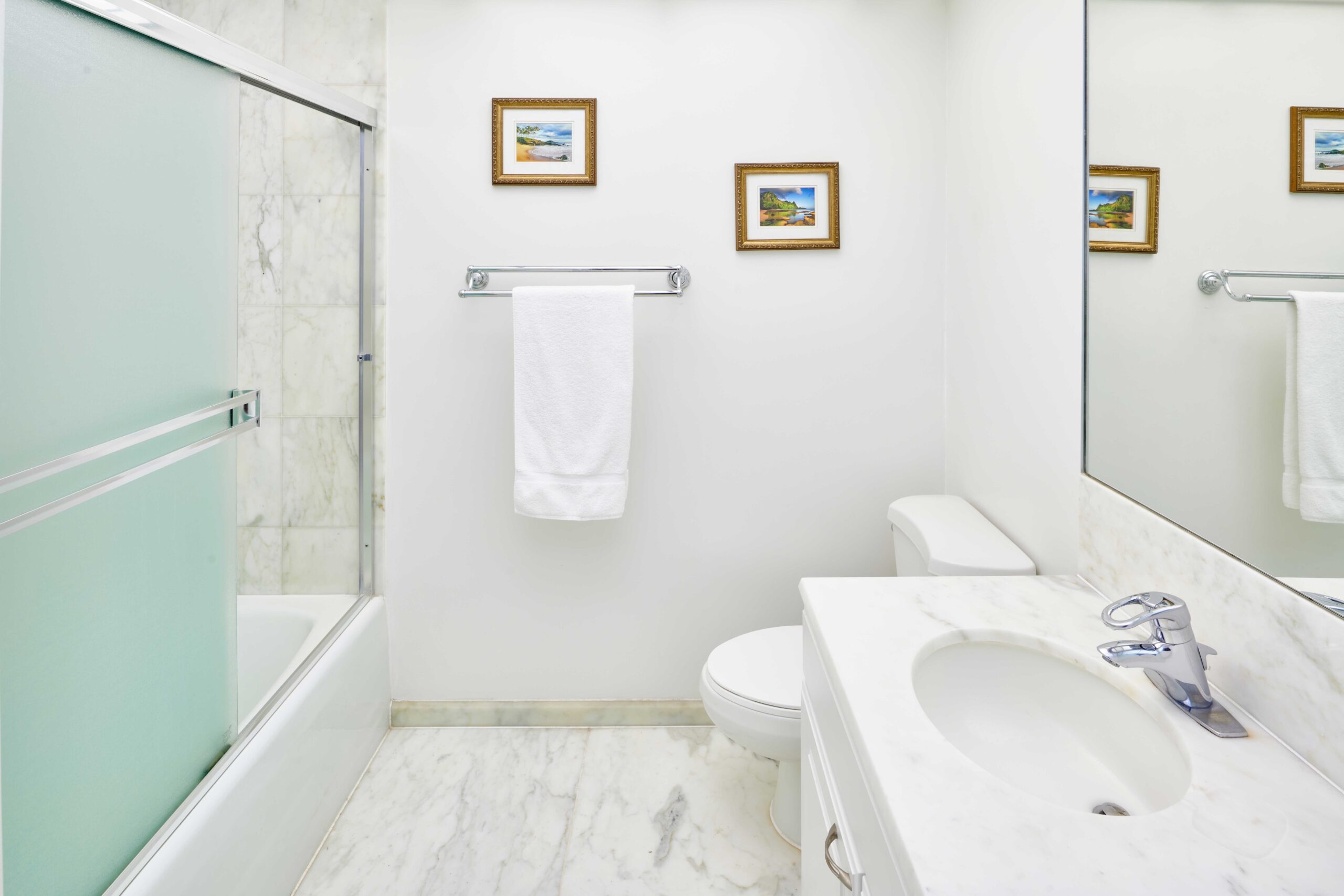 Ocean View Suite bathroom with marble vanity, floor, and shower backsplash