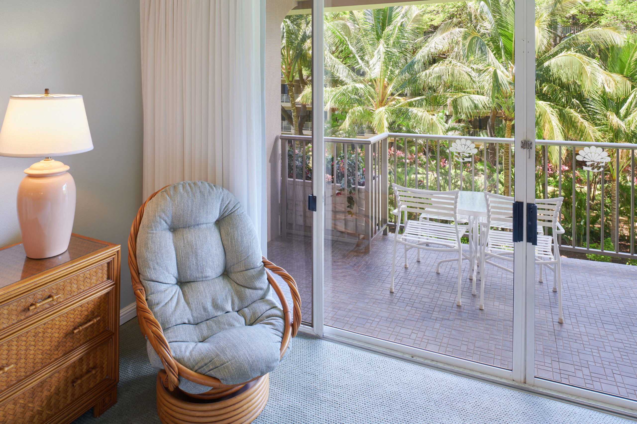 Balcony garden view with cushioned bucket seat and dresser