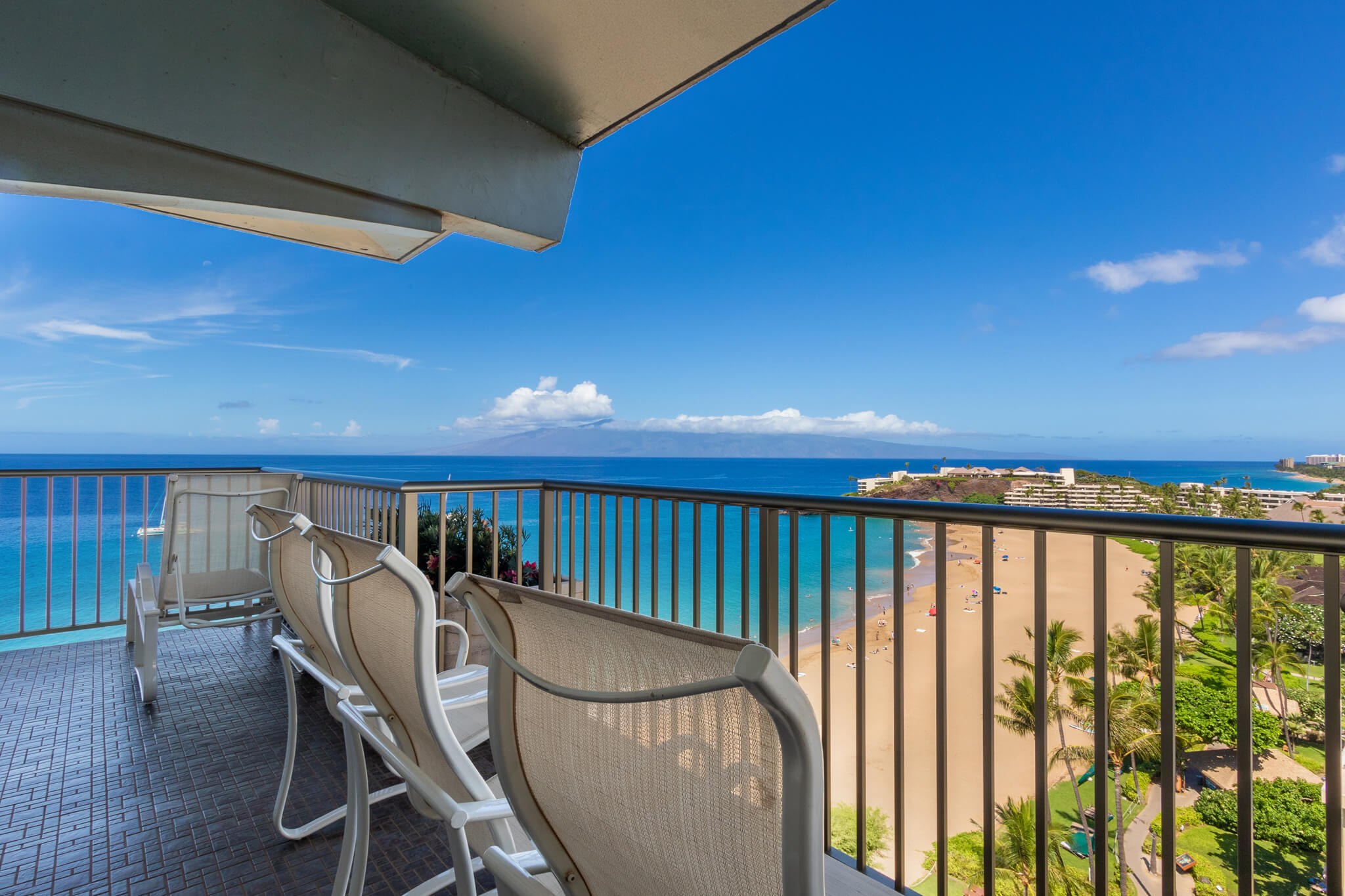 Balcony with chairs and beachfront views.