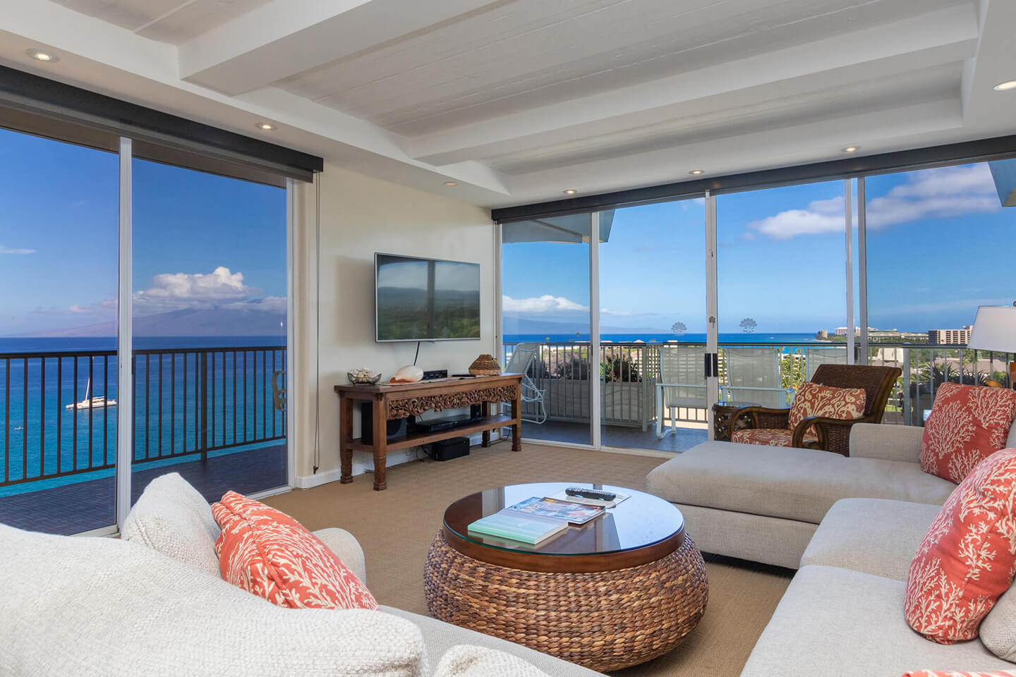 Living area with a couch, TV, and balcony with ocean views.